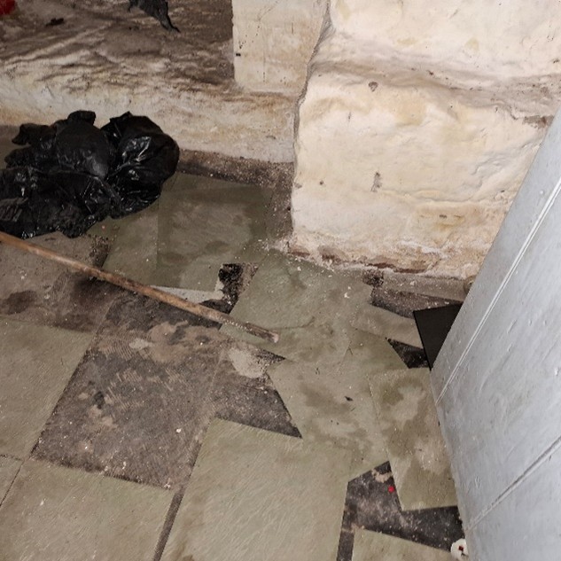 Badly deteriorated asbestos containing floor tiles and adhesive in a school basement